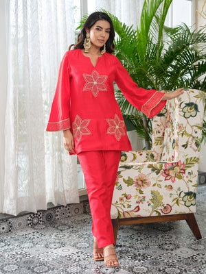 This elegant top is tailored in rich silk fabric, blending timeless allure with a modern edge. The front is adorned with intricately embroidered floral motifs, delicately rendered in golden zari and enhanced with fine hand-embellished kadhana work for depth and dimension. The embroidery extends gracefully along the sleeves, creating a seamless flow of artistry and balance. A perfect expression of classic charm reimagined through contemporary elegance, this piece is designed for effortless sophistication.