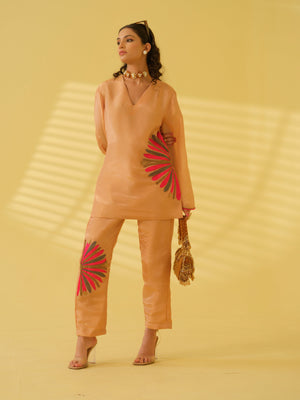 Elevate your festive wardrobe with this vibrant top that blends traditional elegance with modern flair. Crafted from a luxurious, light-reflective fabric, it features a relaxed V-neck silhouette that offers effortless comfort and sophistication. The standout detail is the bold embroidery across the design and hemline, adding a touch of contemporary artistry to its refined aesthetic. Bell sleeves and subtle edge detailing lend a polished yet playful charm, making it perfect for daytime celebrations.