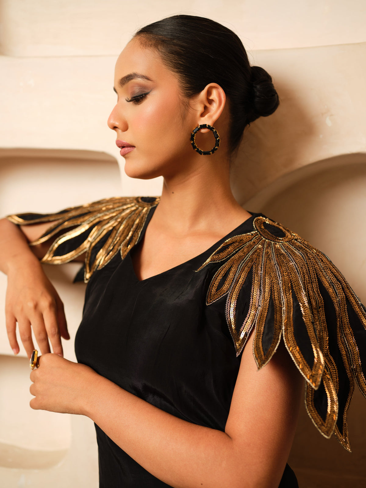 Crafted in premium Natural Crepe, this designer co-ord set features stunning cape-inspired cutwork shoulders adorned with pure hand embroidery, golden metallic sali, and kadhana work. Paired with matching flared trousers, it is a perfect blend of contemporary elegance and artisanal craftsmanship for festive and occasion wear.