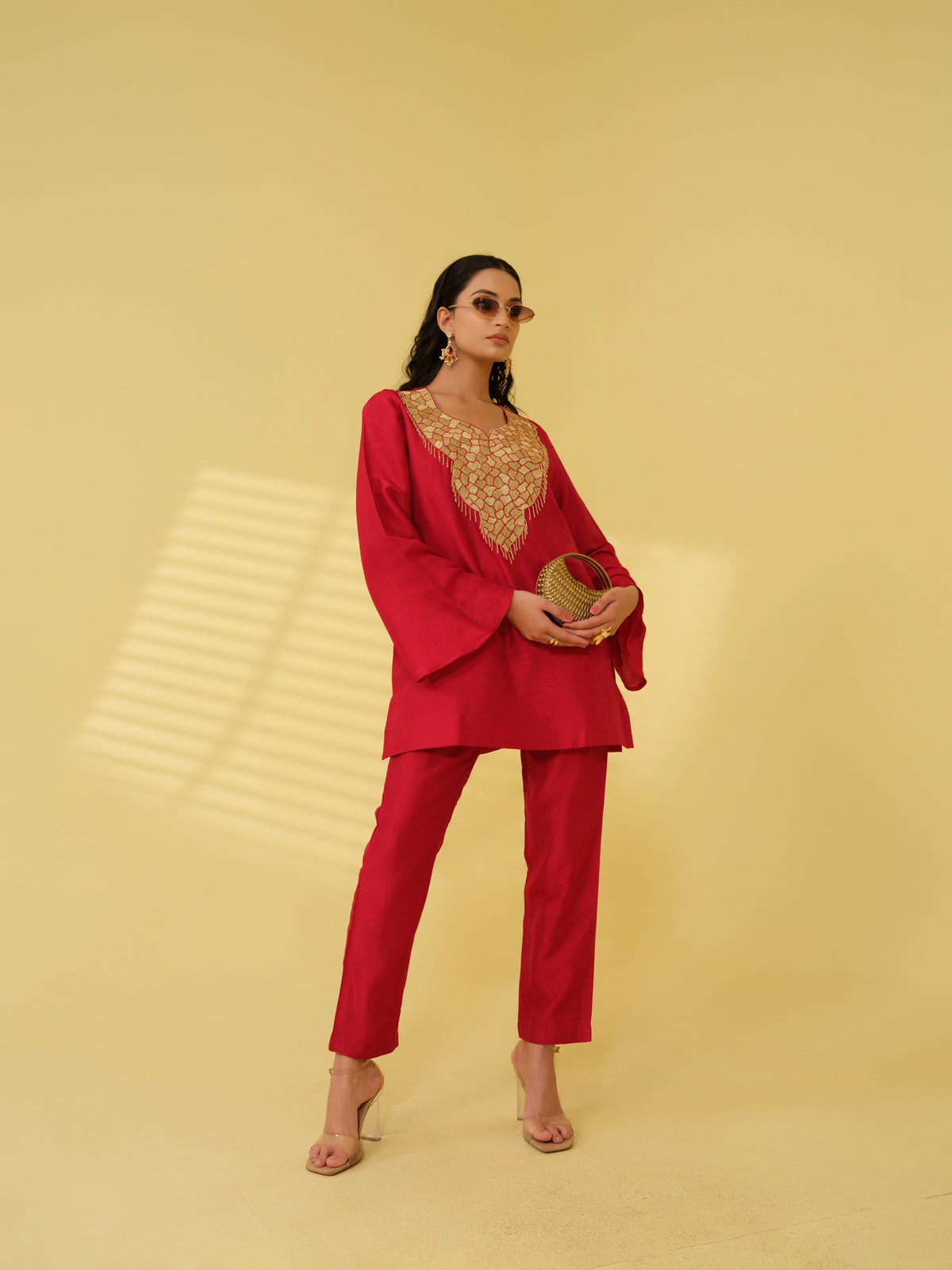 Step into effortless elegance with these luxurious co-ord sets, available in radiant marigold yellow and deep crimson red. The co -ord set features a meticulously embellished neckline, combining the precision of zari machine embroidery with the charm of delicate handwork detailing, creating a rich and intricate design that exudes traditional artistry. The flared sleeves and straight-cut silhouette add a graceful, contemporary touch, while the coordinated pants offer a clean, polished finish.