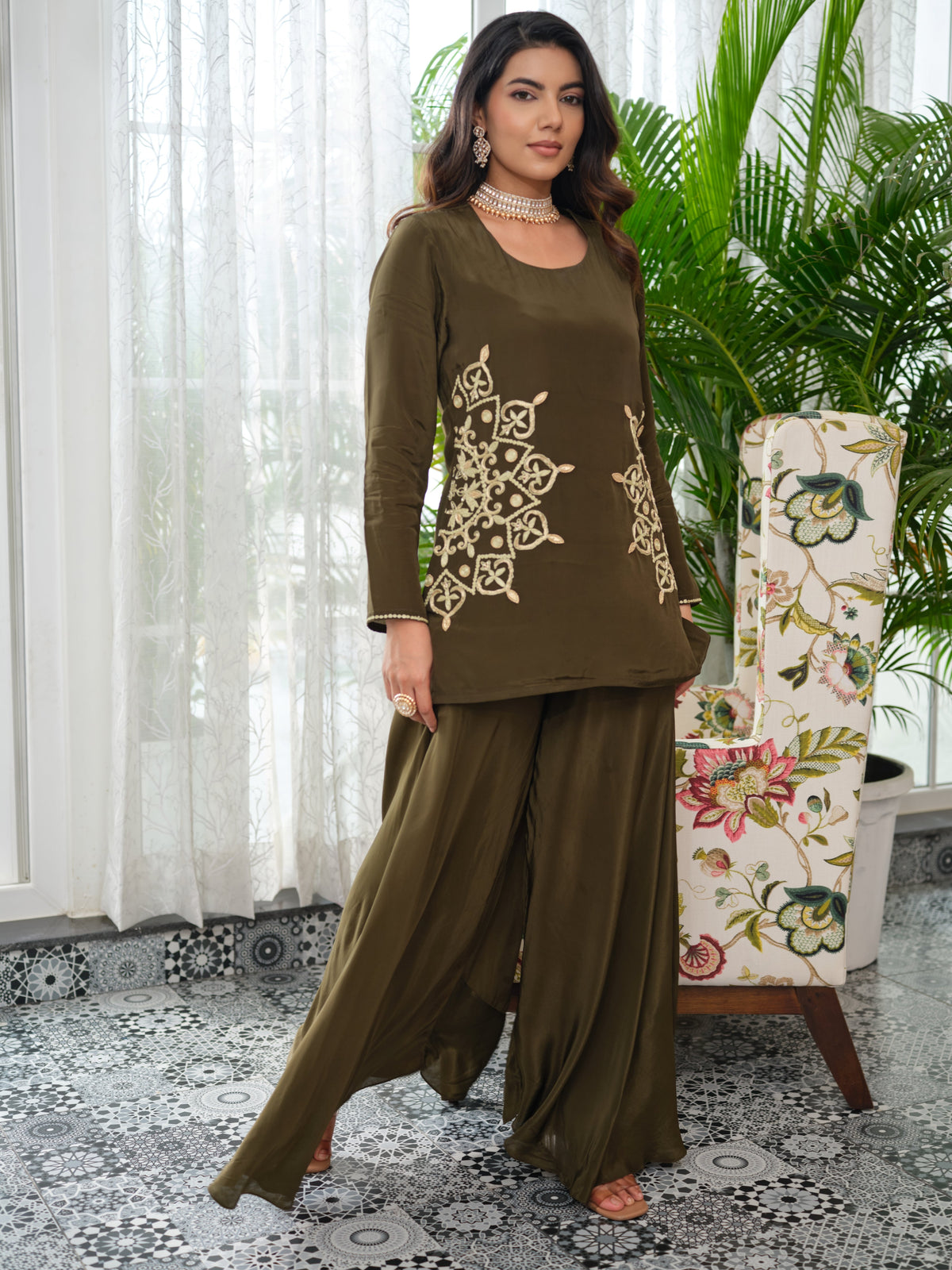 This refined top is tailored in luxurious crepe fabric, adorned with intricate embroidery and hand embellishments. Accented with golden zari and delicate kadhana work, the design embodies timeless artistry with a contemporary edge. The detailing extends gracefully across the sleeves, creating an elegant statement from every angle. An ode to effortless charm, this piece is crafted for the modern muse who embraces tradition with a touch of contemporary sophistication.