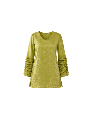 This elegant top is crafted from soft crush organza fabric in a beautiful pistachio green shade. Lightweight and delicately textured, the fabric offers a subtle sheer finish that adds a touch of luxury and modern sophistication. The design features a relaxed, flowy silhouette that blends comfort with effortless grace. Dramatic pleated detailing on the sleeves creates beautiful movement and dimension, lending the piece a structured yet fluid appeal. Finished with a minimal V-shaped neckline.