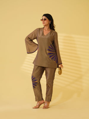 Elevate your festive wardrobe with this vibrant top that blends traditional elegance with modern flair. Crafted from a luxurious, light-reflective fabric, it features a relaxed V-neck silhouette that offers effortless comfort and sophistication. The standout detail is the bold embroidery across the design and hemline, adding a touch of contemporary artistry to its refined aesthetic. Bell sleeves and subtle edge detailing lend a polished yet playful charm, making it perfect for daytime celebrations